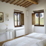 Bedroom 2 – a twin bedded room with wardrobe, dressing table, storage bench and overlooking the pool